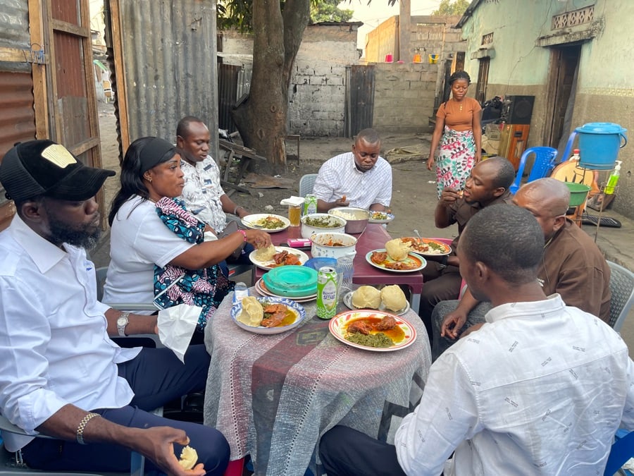 Vue d'ensemble du groupe assis autour du repas dans la cour