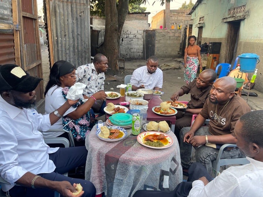 Groupe de personnes assises autour d'une table partageant un repas en extérieur